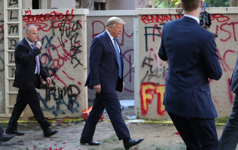 Presidente Donald Trump passa ao lado de muro pichado em Washington, nos EUA, ao seguir para igreja nesta segunda-feira (1º) — Foto: Tom Brenner/Reuters