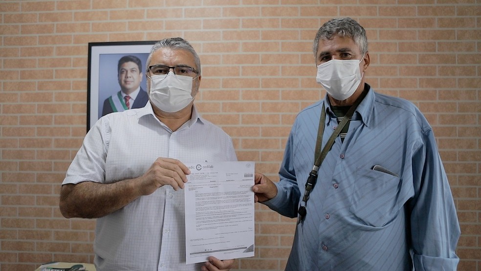 Secretário de Saúde Gonçalo Barros entrega resultado de exame a João Evangelista dos Santos — Foto: Assessoria