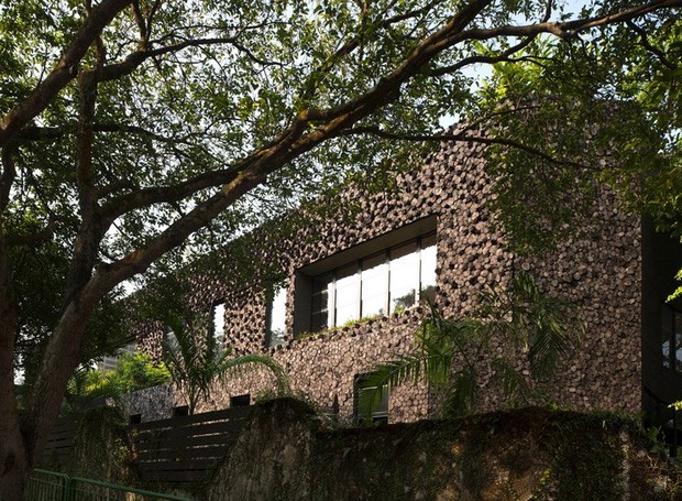 Pequenos troncos formam as paredes das fachadas, filtrando o ar que adentra o espaço (Foto: Desingboom/ Reprodução)