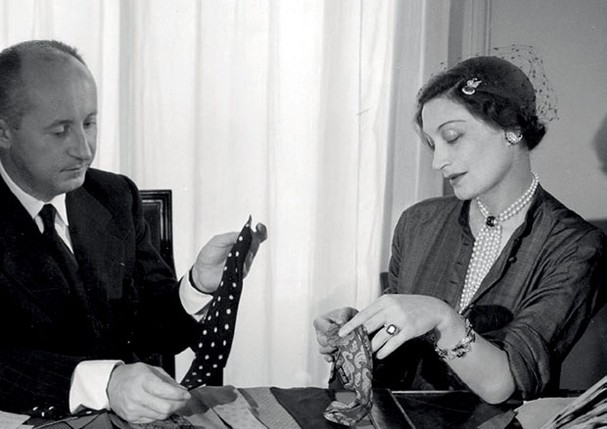  Christian Dior ao lado de Mitzah Bricard, uma de suas maiores musas e colaboradoras, em 1949.  (Foto: Association Willy Maywald/ADAGP, 2021 e Divulgação)