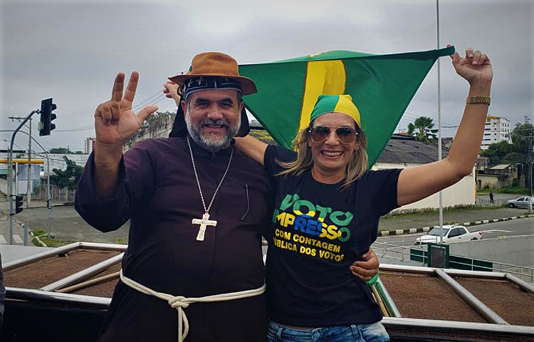 O novo candidato do PTB, Padre Kelmon, ao lado de apoiadora de Bolsonaro durante manifestação de 1º de agosto de 2021  — Foto: Reprodução / Facebook