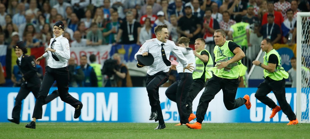 Grupo Pussy Riot corre pelo campo apÃ³s invadir gramado na final da Copa do Mundo da RÃºssia (Foto: Odd ANDERSEN / AFP)