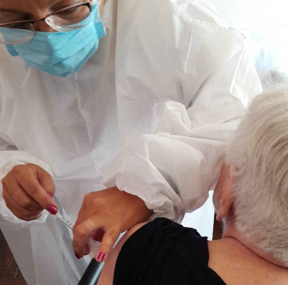 Senhora toma vacina contra a Covid-19
