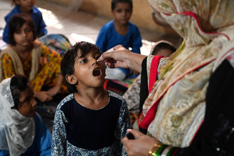 Agente de saúde administra a vacina contra a poliomielite em uma escola durante uma campanha de vacinação em Lahore, no Paquistão