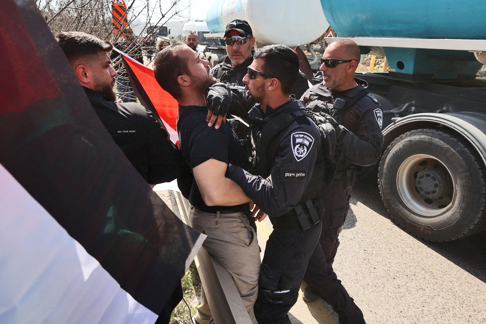 Ativistas da paz – palestinos e israelenses – protestam na entrada de Huwara, alvo de ataque extremista, na Cisjordânia ocupada — Foto: JAAFAR ASHTIYEH/AFP