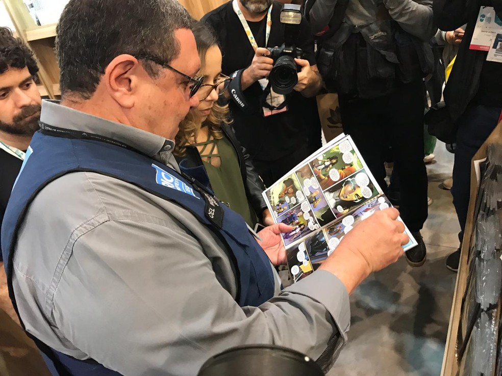 Subsecretário de Ordem Pública folheia livro na Bienal em busca de conteúdo 'impróprio' — Foto: Fernanda Rouvenat / G1