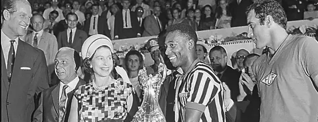 Ao conhecer pessoalmente o jogador Pelé, a rainha disse "Já o conheço de nome. E me sinto muito feliz em cumprimentá-lo". — Foto: Reprodução
