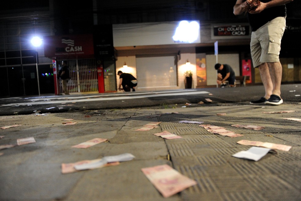 Dinheiro deixado pelos criminosos foi recolhido pelos peritos da polícia em Criciúma — Foto: Caio Marcello/Agif - Agência de Fotografia/Estadão Conteúdo