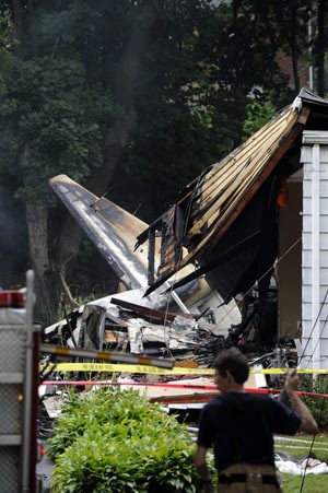 Bombeiro observa o local da queda do avião sobre casa em East Haven, Connecticut, nesta sexta-feira (9) (Foto: Fred Beckham/AP)