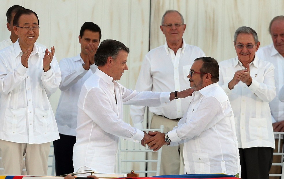 Juan Manuel Santos, presidente da Colômbia, e Rodrigo Londoño, chefe das Farc, se cumprimentam após assinar o acordo de Paz em Cartagena, em 2016 (Foto: Fernando Vergara/AP)
