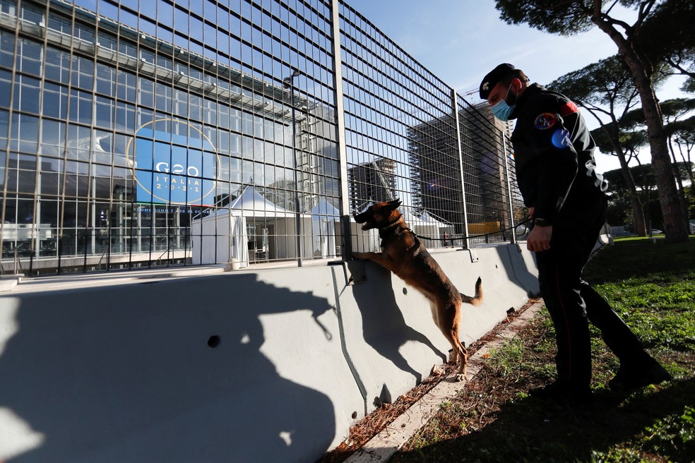 Agente da polícia usa cão para inspecionar área perto do prédio onde ocorrerá o encontro do G20 em Roma, em 27 de outubro de 2021 — Foto: Yara Nardi/Reuters
