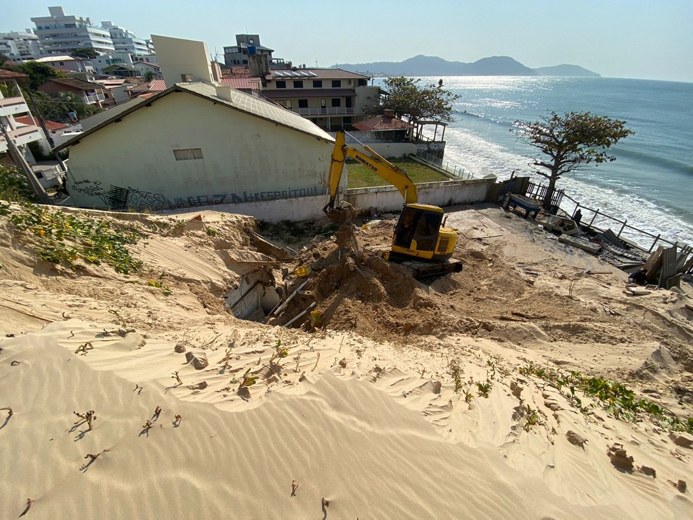 Máquina atua na demolição de imóveis nas dunas do bairro Ingleses, em Florianópolis — Foto: Defesa Civil/Divulgação