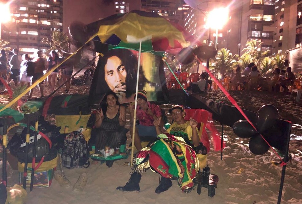 Família monta uma tenda completamente decorada com imagens do cantor jamaicano Bob Marley e as cores do reggae para celebrar 2019 no Recife — Foto: Pedro Alves/G1