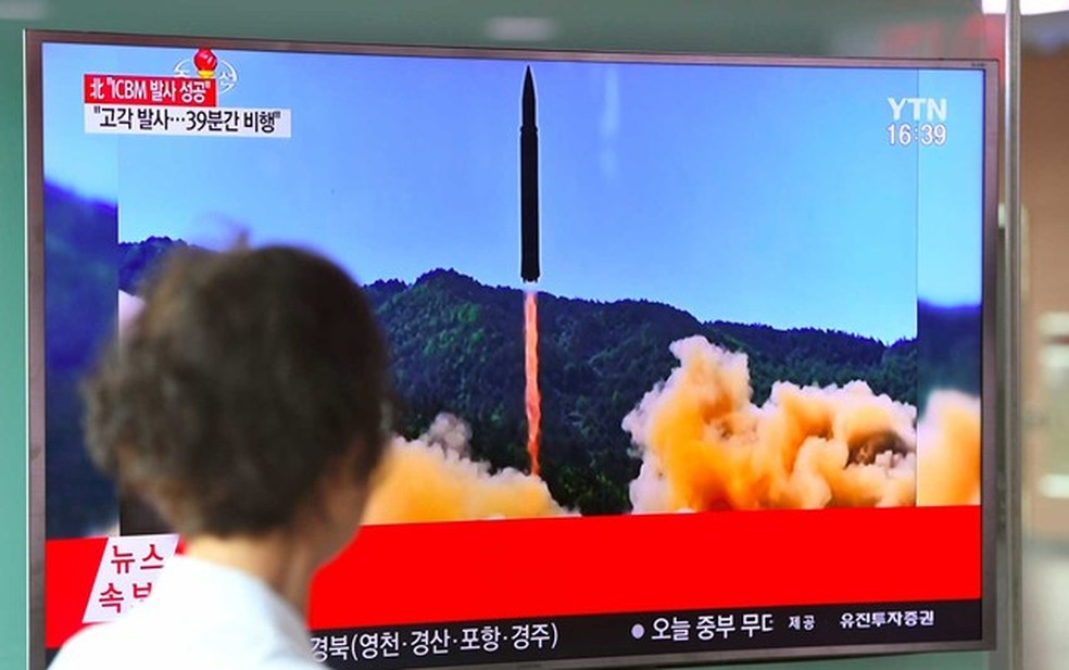 Uma mulher observa uma TV de uma estação ferroviária de Seul, na Coreia do Sul, que mostra imagem de um lançamento de míssil balístico da Coreia do Norte (Foto: Jung Yeon-Je / AFP Photo)