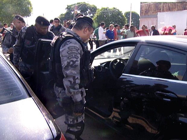 Policiais militares observam corpo do assaltante dentro do carro (Foto: TV Globo/ Reprodução)