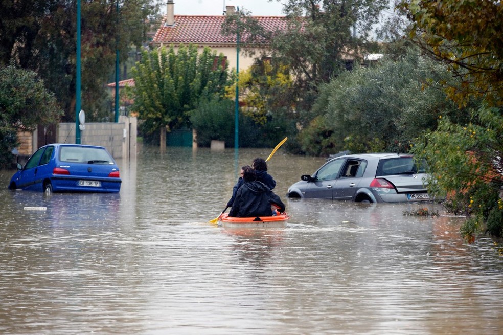 Pessoas se locomovem em bote na cidade de Le Muy, no Sul da França, depois de inundações  — Foto: Valery Hache/AFP