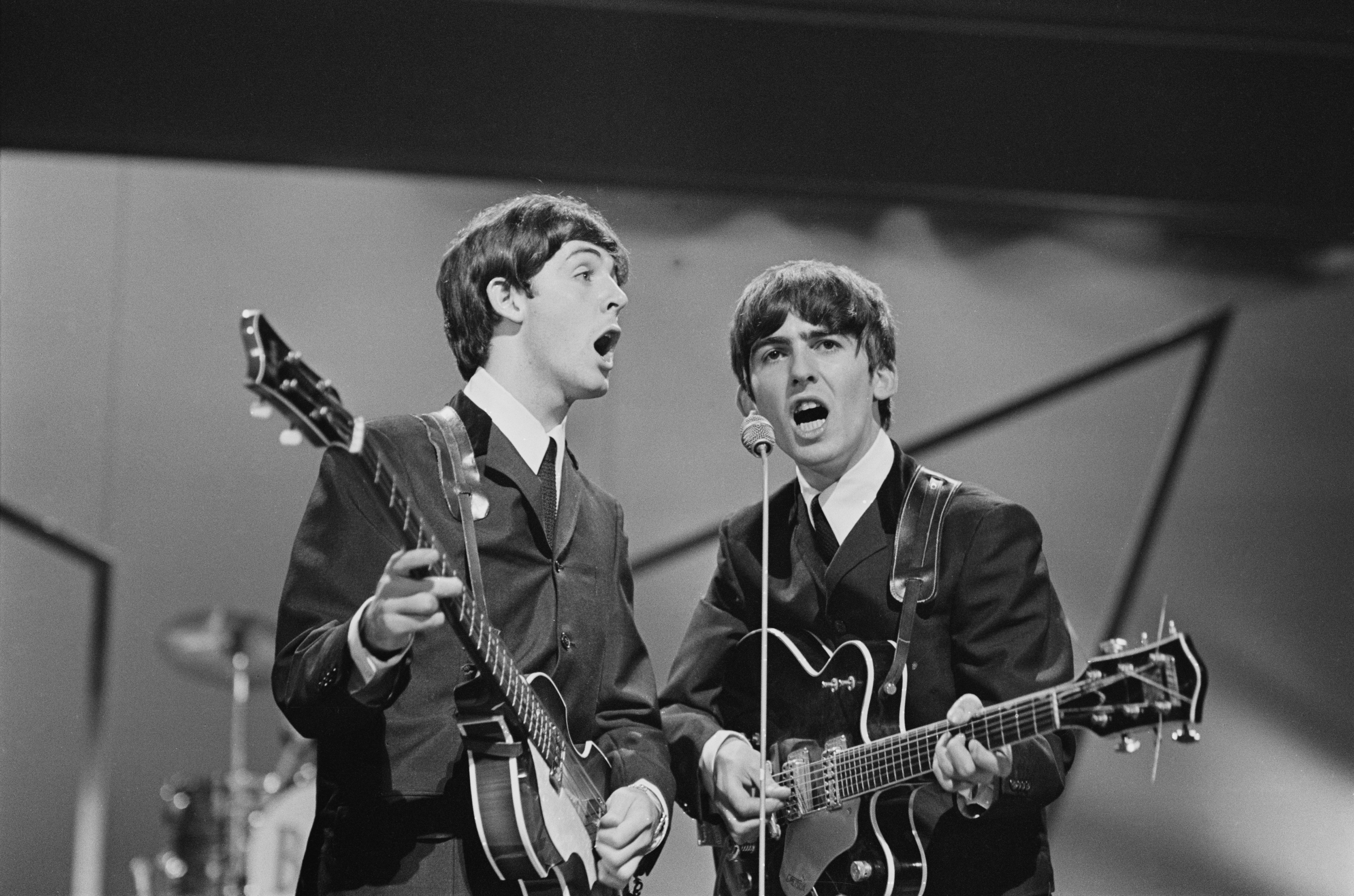Paul McCartney e George Harrison (1943-2001) em um show do Beatles em Londres em outubro de 1963 (Foto: Getty Images)