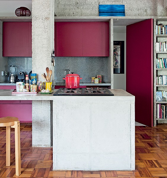 Adepto da arquitetura brutalista, o arquiteto Eduardo Chalabi fez bancada de concreto armado para a cozinha. Os armários são da cor vinho – tonalidade quente que contrasta com o cinza (Foto: Fran Parente/Casa e Jardim)