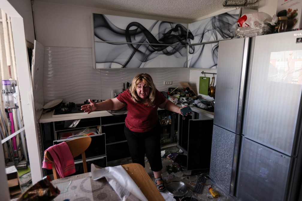 Uma mulher reage na cozinha de seu apartamento após o prédio ser atingido por um foguete de Gaza em Ashdod, Israel, nesta segunda (17)  — Foto: Ronen Zvulun/Reuters