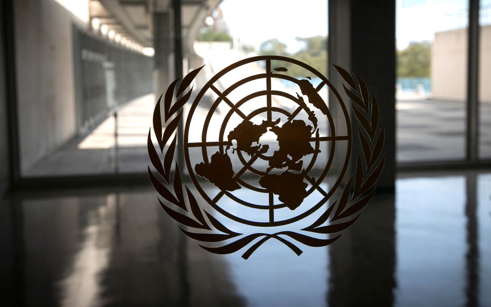 Logo da ONU é visto em janela de salão vazio da sede da Organização durante debate virtual da Assembleia Geral, em Nova York, na segunda-feira (21) — Foto: Reuters/Mike Segar 