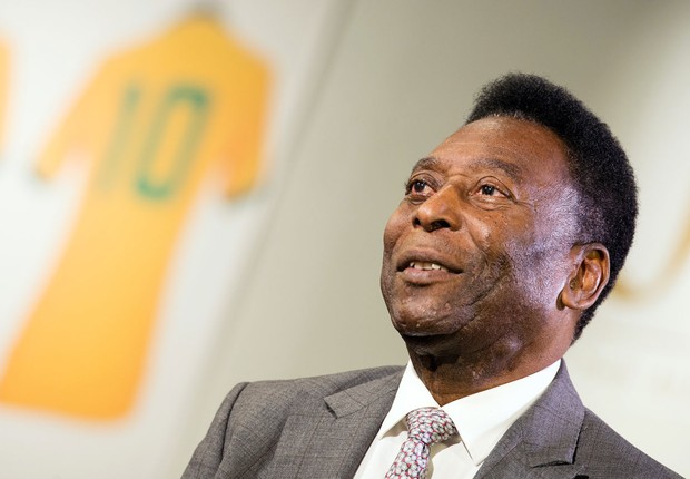 O ex-jogador de futebol Pelé posa ao lado das peças leiloadas a partir de seu acervo, como a camisa 10 da seleção brasileira (Foto: Jeff Spicer/Getty Images)