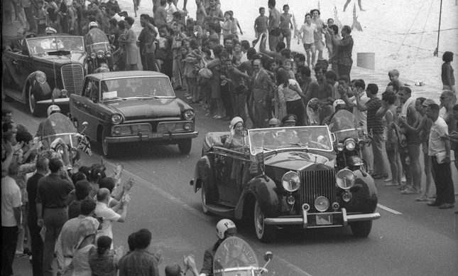 A rainha e o príncipe desfilam de carro aberto pela Avenida Atlântica, no Rio