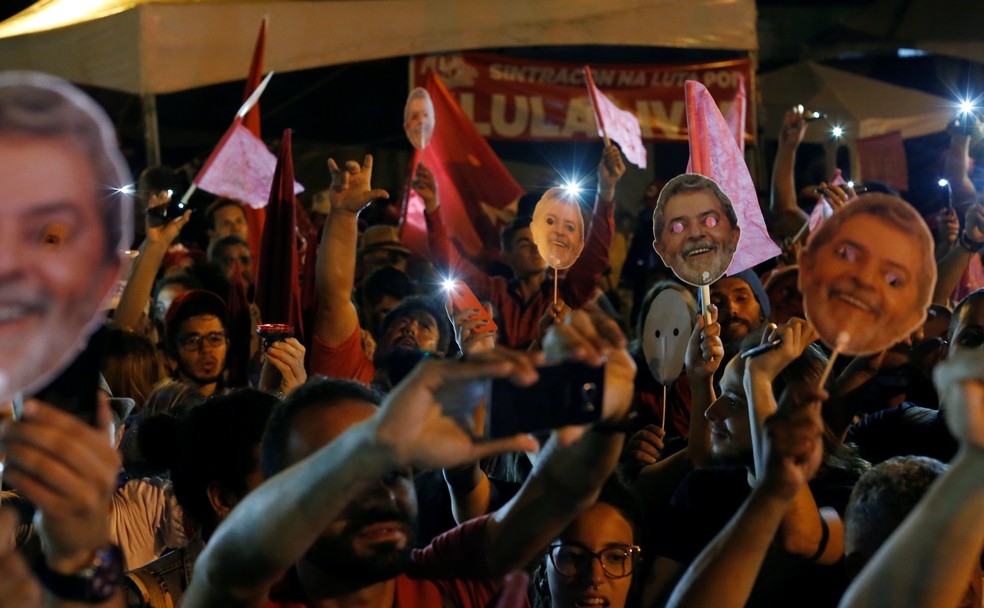 Apoiadores exibem máscaras do ex-presidente Lula em acampamento no entorno da Superintendência da Polícia Federal, onde o ex-presidente está preso, em Curitiba  (Foto: Rodolfo Buhrer/Reuters)