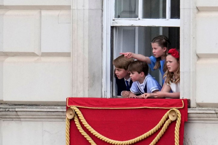 Bisnetos da rainha Elizabeth assistem à parada militar de uma das janelas de Buckingham: princesa Charlotte aponta para o desfile, ao lado de Isla Phillips e dos príncipes George (esquerda) e Louis — Foto: MATT DUNHAM/AFP