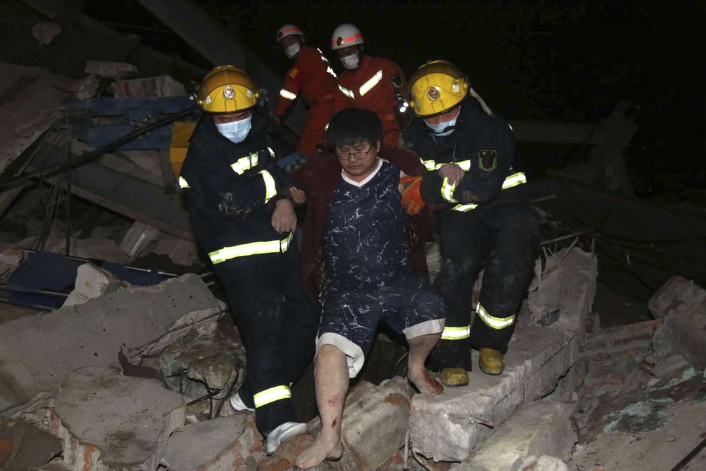 Bombeiros resgatam sobrevivente de desabamento de hotel com pessoas em quarentena por coronavírus na China — Foto: Chinatopix via AP