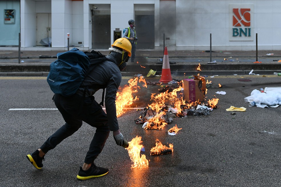 Manifestante coloca fogo em destroços na rua durante manifestação em Hong Kong, nesta terça-feira (1º)  — Foto: Mohd Rasfan / AFP