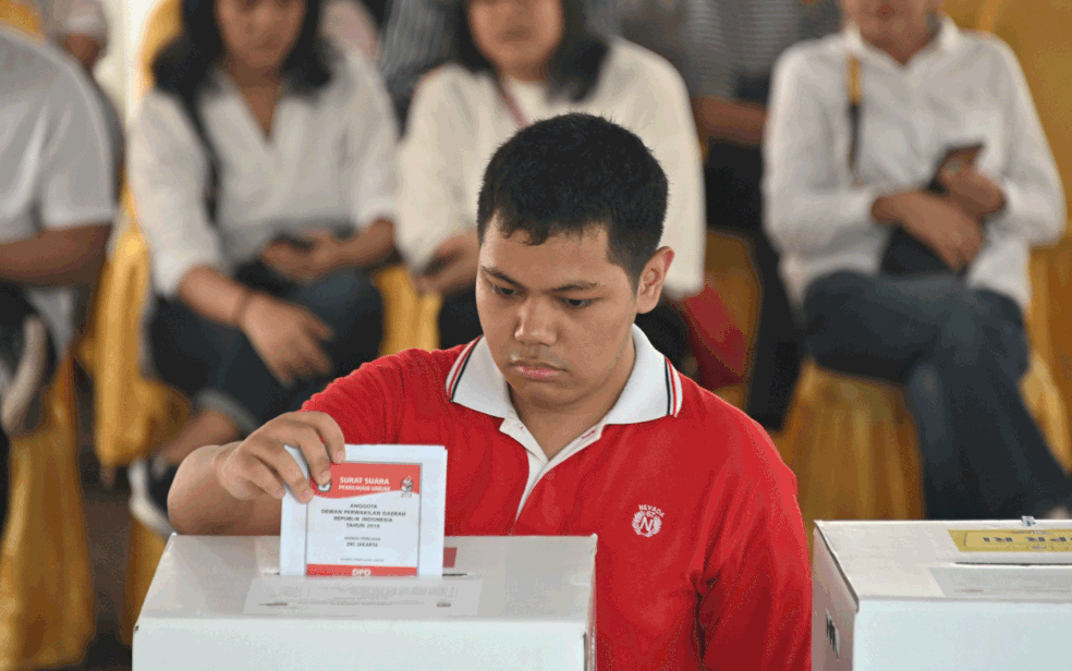 Um indonésio deposita cédula em um centro de votação durante a eleição presidencial e legislativa em Jacarta — Foto: Bay Ismoyo / AFP Photo  