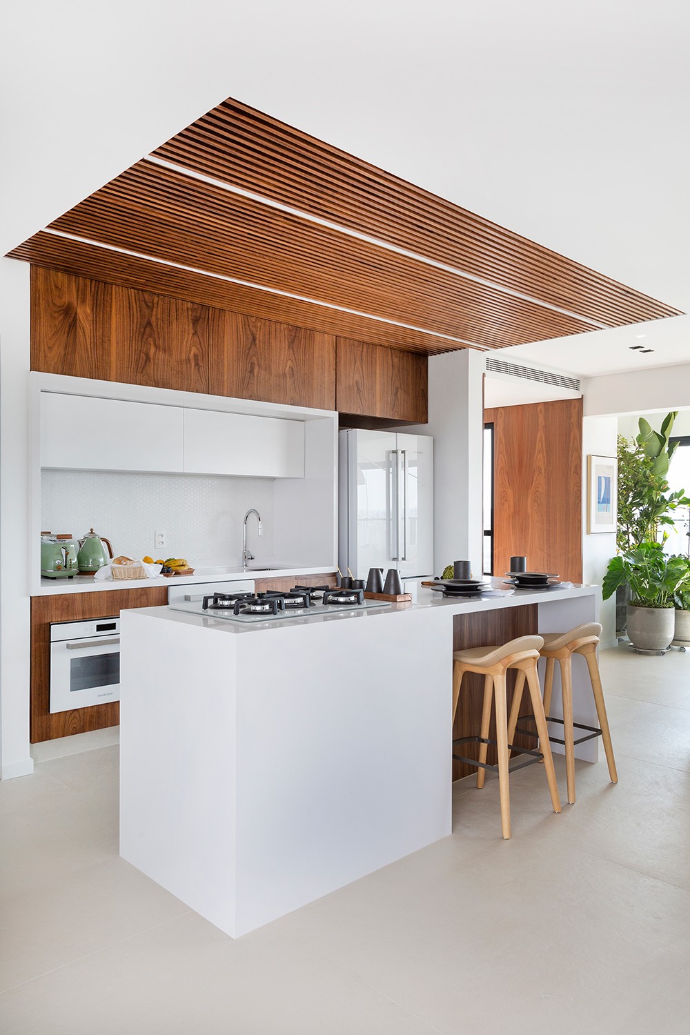KITCHEN |  The wooden ceiling delimited the kitchen area.  The island allows those who are cooking to stay in touch with those in other environments.  Stools are from Dpot (Photo: Julia Ribeiro / Disclosure)
