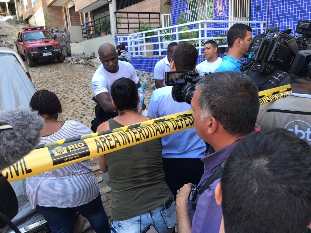 Moradores da região dão água a bombeiros que trabalham no resgate às vítimas do desabamento de dois prédios no Rio — Foto: Raísa Pires/G1