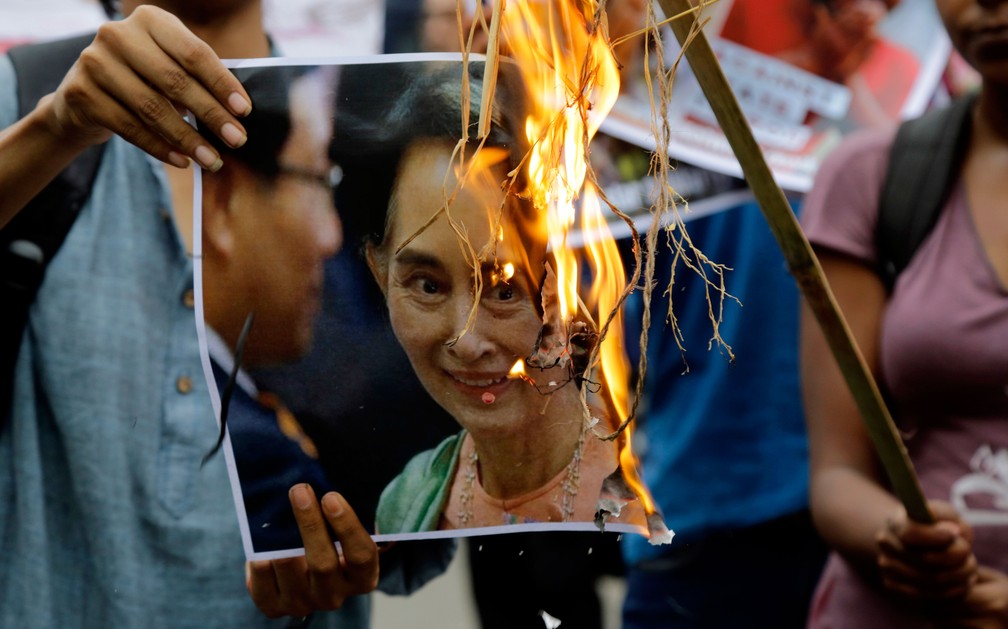 Ativistas queimam foto de Aung San Suu Kyi no protesto em Calcutá, na Índia, contra a perseguição dos Rohingyas em Mianmar  (Foto: Bikas Das/AP)