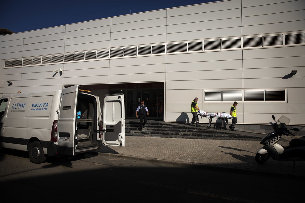 Policiais removem corpo de agressor que tentou agredir com faca agente em delegacia de Cornella de Llobregat, na Espanha (Foto: Emilio Morenatti/AP Photo)
