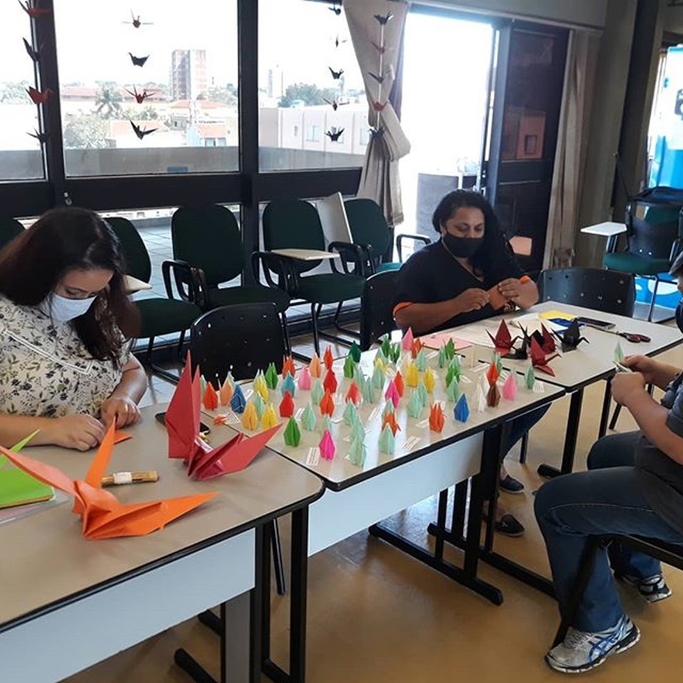 Funcionários fazendo origamis para distribuírem em asilo de MS — Foto: Fundação de Cultura/Divulgação