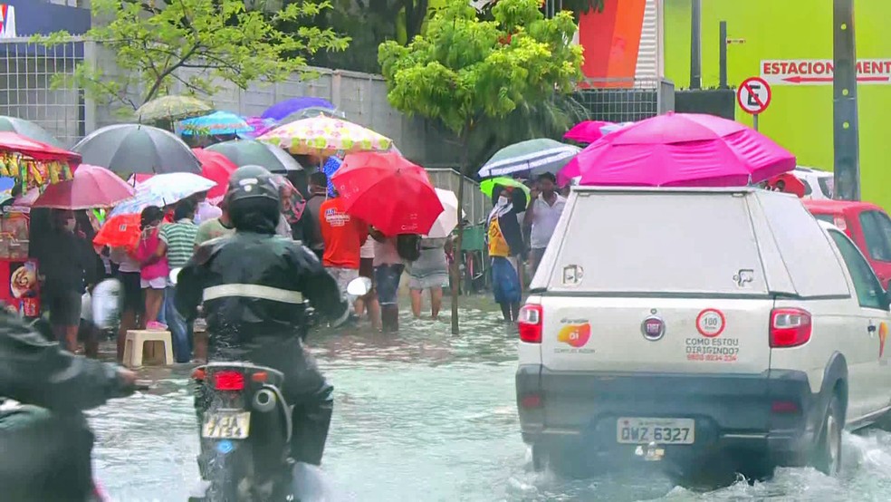 Mesmo com alagamento e chuva, população aguarda abertura da agência da Caixa na Encruzilhada, Zona Norte do Recife, nesta segunda-feira (27) — Foto: Reprodução/TV Globo