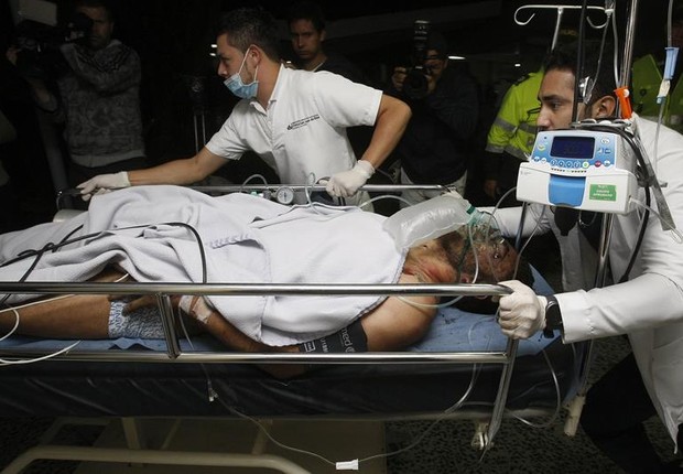 Médicos e enfermeiros da Clínica San Juan de Dios transportam o jogador brasileiro Alan Ruschel, um dos sobreviventes do acidente com o avião que transportava o time do Chapecoense na Colômbia (Foto: Luis Eduardo Noriega A./EFE)