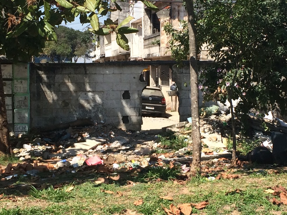 Muro do Cemitério Vila Nova Cachoeirinha quebrado permite entrada de lixo, entulho e até móveis no local  (Foto: Glauco Araújo/G1)