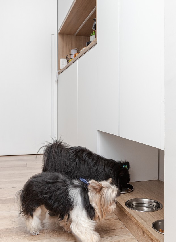 Na parte de baixo do armário da cozinha, os comedouros dos cachorros foram colocados em um nicho no projeto assinado pelo escritório Arquiteto em Casa (Foto: Gisele Rampazzo / Divulgação)