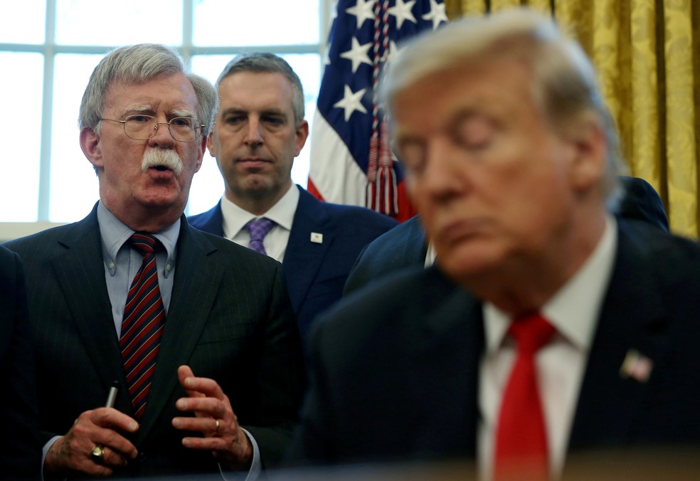 Em imagem de fevereiro de 2019, Donald Trump escuta John Bolton, então seu conselheiro de segurança, falar — Foto: Leah Millis/File Photo/Reuters
