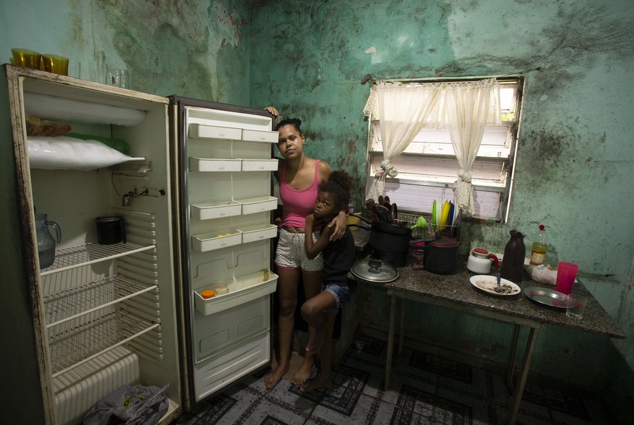 Natália Soares da Silva, moradora de Nova Iguaçu, na Baixada Fluminense, mostra a geladeira vazia