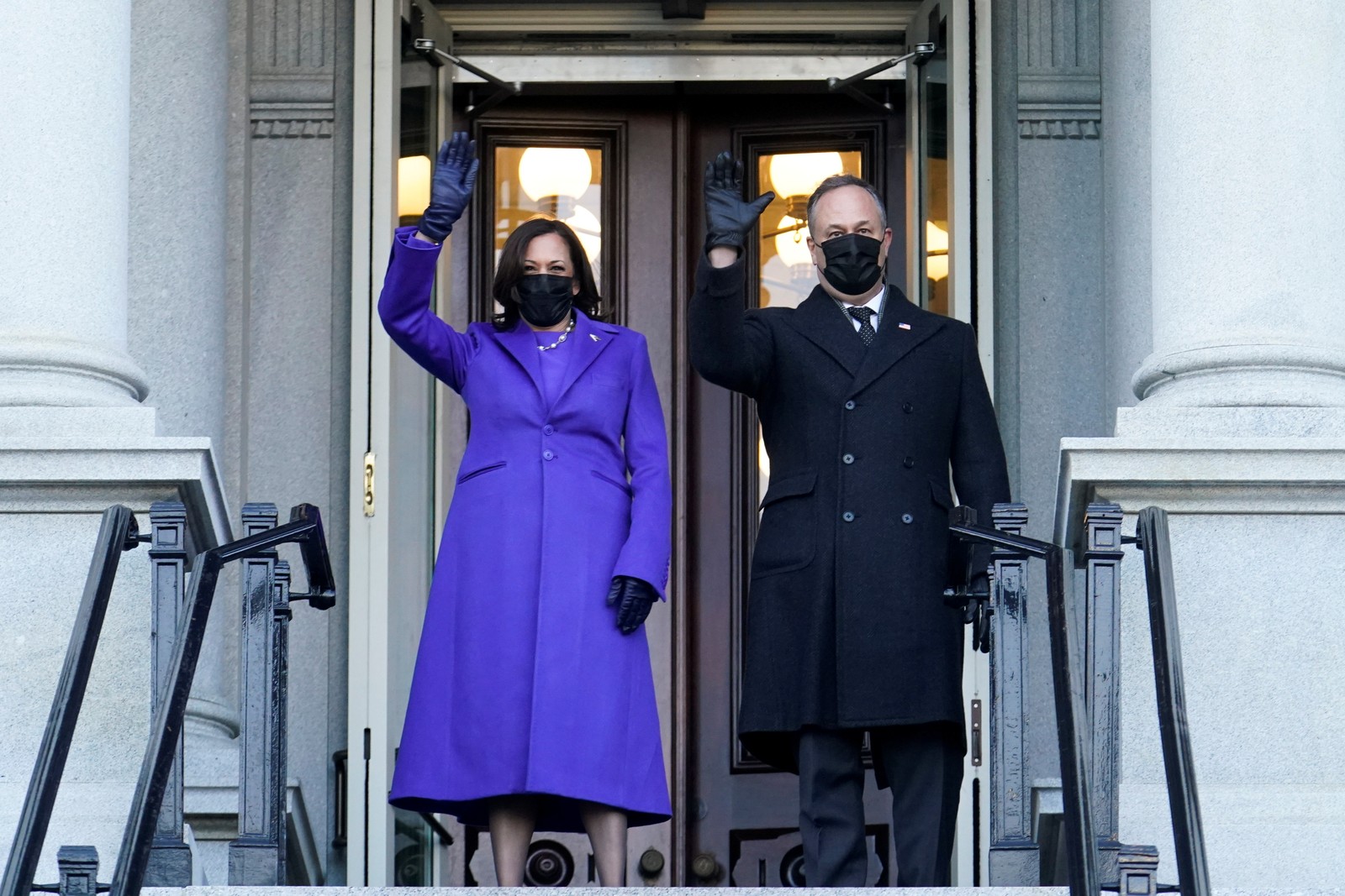 A vice-presidente, Kamala Harris, e seu marido, Douglas Emhoff, acenam da entrada do Eisenhower Executive Office Building, na Casa Branca. Casal repetiu a caminhada Biden até a sede do governoREUTERS