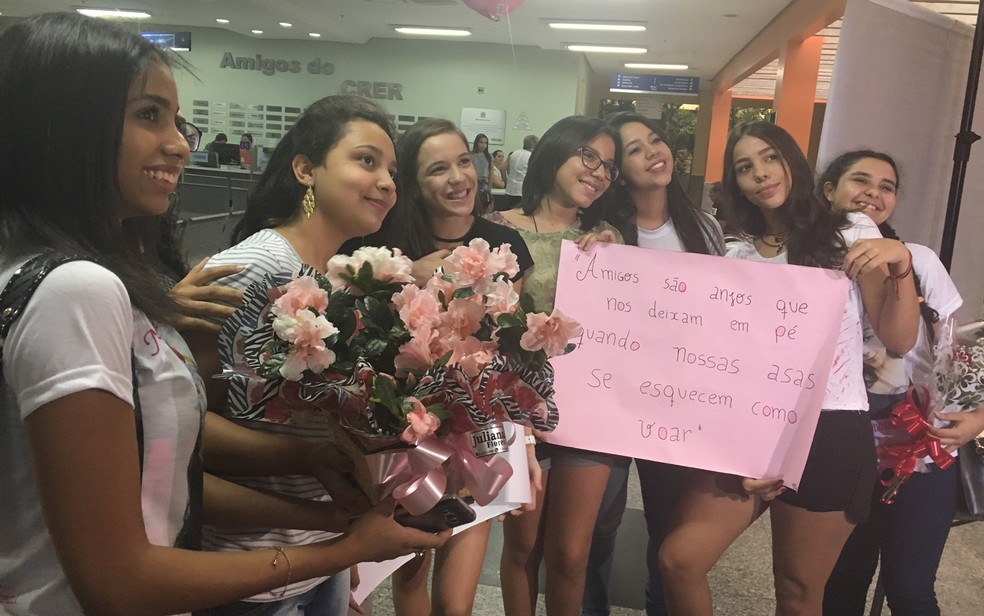 Amigas de Isadora de Morais levaram flores e cartazes para homenagear estudante, no Crer (Foto: Vanessa Martins/G1)