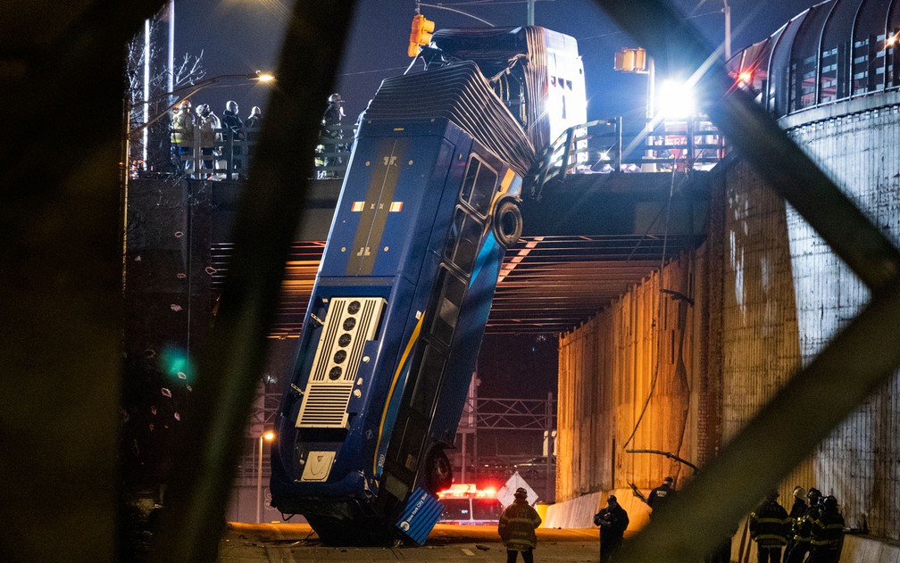 Ônibus articulado que ficou pendurado em ponte no Bronx, em Nova York, após acidente na noite de quinta-feira (14) — Foto: AP Photo/Craig Ruttle