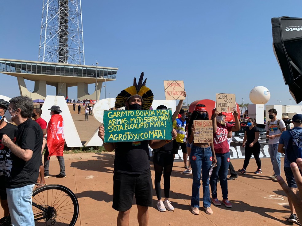 Manifestantes seguram cartazes contra garimpo, Bolsonaro e 'retrocesso', em ato na Torre de TV, em Brasília — Foto: Brenda Ortiz/G1