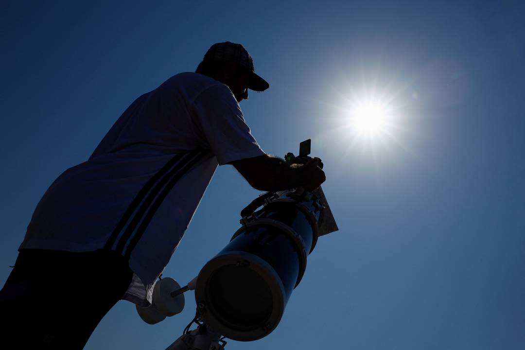 O francês Leyssalle Anthony, de 39 anos, prepara um telescópio na praia de Arija, na Espanha, para observar o eclipse solar total nesta quarta-feira (12).