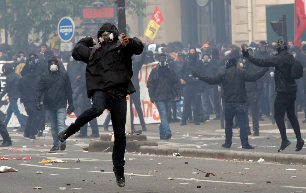 Homem encapuzado joga pedras em protesto do Dia do Trabalho em Paris (Foto: Philippe Wojazer/Reuters)