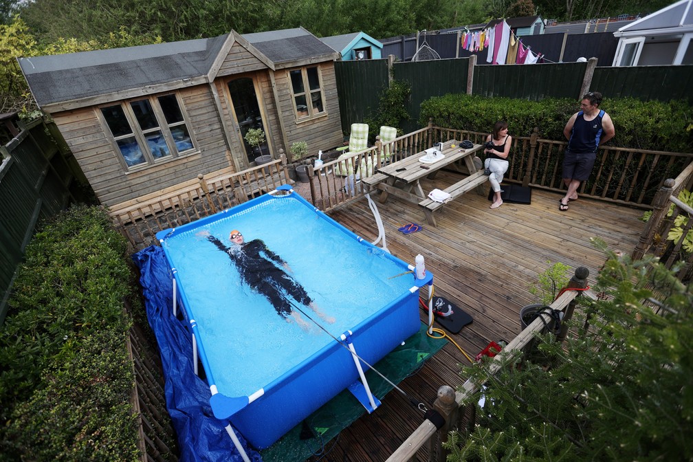26 de abril - O triatleta Lloyd Bebbington treina em uma piscina instalada em seu jardim em casa durante a pandemia do novo coronavírus (Covid-19) em Newcastle-under-Lyme, no Reino Unido — Foto:  Carl Recine/Reuters
