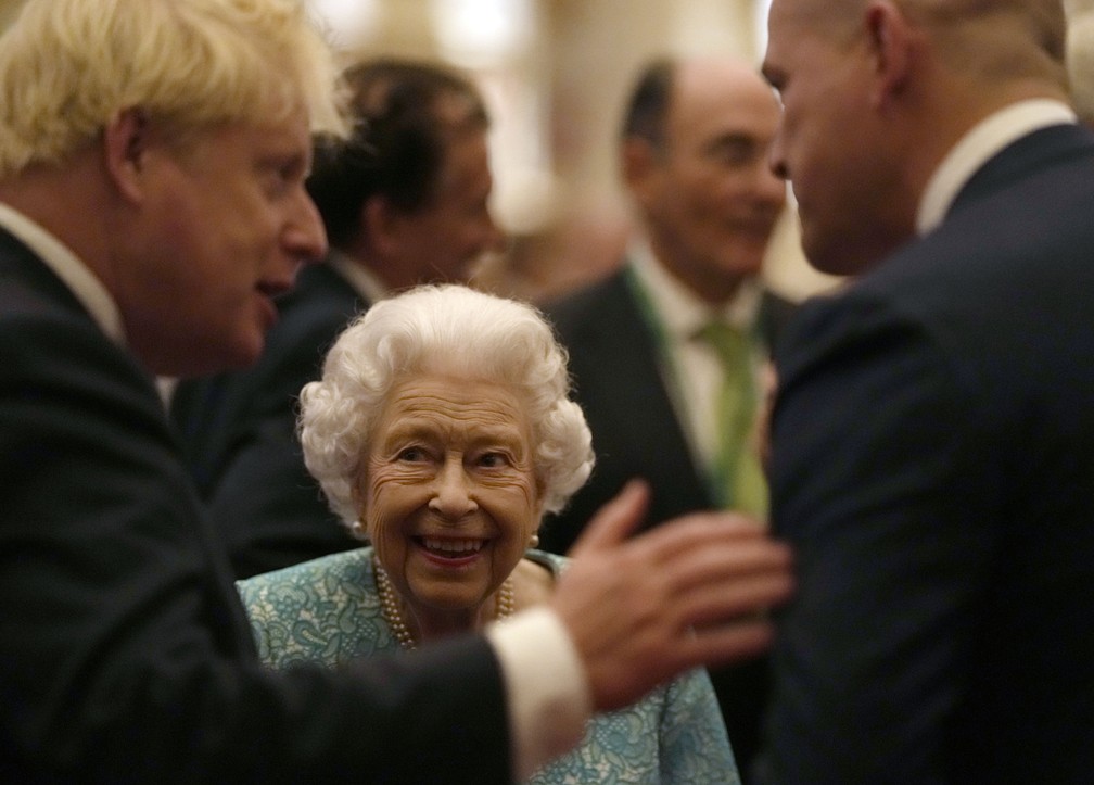 A rainha Elizabeth II da Grã-Bretanha observa o primeiro-ministro Boris Johnson (à esquerda) conversar com convidado em evento da Cúpula de Investimento Global, no Castelo de Windsor, em 19 de outubro de 2021 — Foto: Alastair Grant/Pool via AP